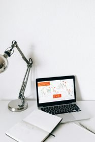 A sleek workspace featuring a laptop displaying data analysis charts, perfect for business and technology themes.