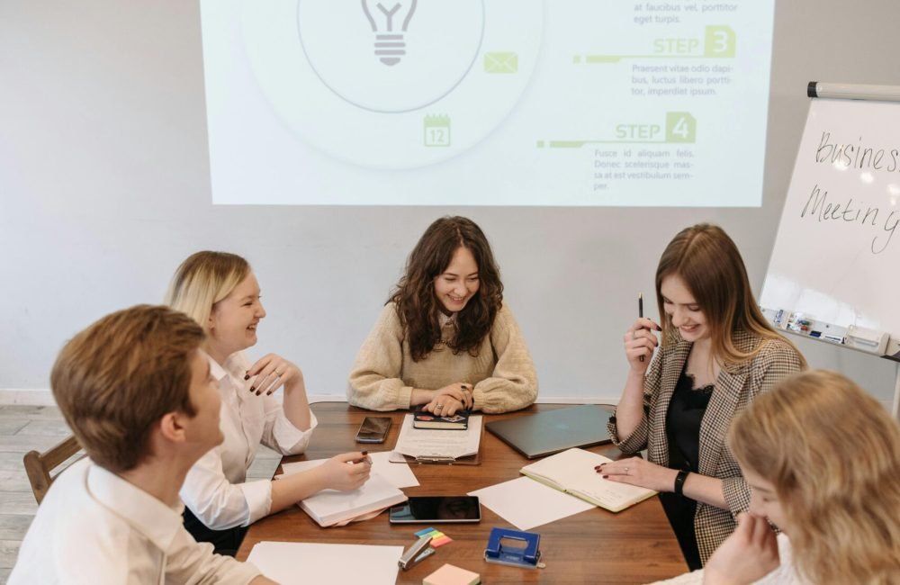 Team discussing ideas at a business meeting with a presentation in the office.