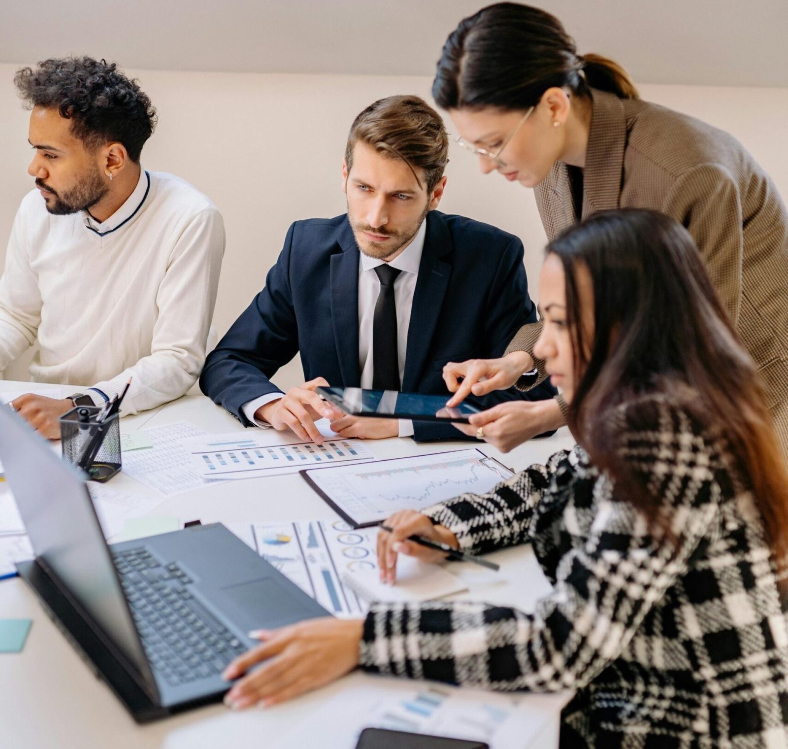 Professionals engaged in a meeting discussing plans in a modern office setting.